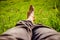 Chilling in the green grass: Legs of a young man, relaxing, summertime