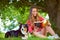 Chilling at the park with her best buddy. a young woman reading a book while sitting with her dog under a tree.