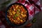 Chilly beans with hot pepper on dark wooden background