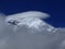 Chimborazo mountain tops covered in snow and surrounded with clouds under the blue sky