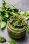 Chimichurri sauce. Argentine green parsley basil sauce chimichurri for barbecue asado in glass jar, gray slate