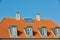 Chimney chutes, windows and sunroof skylight designed on house building outside against blue sky background