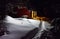 Chimney light of a cottage illuminate the snow outside at winter