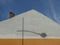 Chimney on the roof of a house with street lamp shadow on the wall