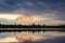 Chimney smoldering mirroring in water with rain clouds