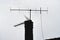 Chimney and television aerials silhouette on a roof in a foggy day, monochromatic