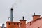 Chimneys on the roofs of single-family houses. Smoke rising over the roofs of a small town