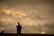 chimneys silhouettes and crow silhouettte on cloudy sky by sunset