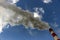 Chimneys with steam production of a thermal power station. Cloudy sky is polluted by smoke from the chimney