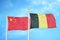 China and Belgium two flags on flagpoles and blue cloudy sky