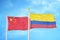 China and Colombia two flags on flagpoles and blue cloudy sky