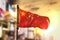 China Flag Against City Blurred Background At Sunrise Backlight