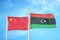 China and Libya two flags on flagpoles and blue cloudy sky