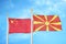 China and North Macedonia two flags on flagpoles and blue cloudy sky