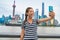 China travel Asian girl tourist taking phone selfie photo on the Bund in Shanghai city vacation. Happy chinese young woman using