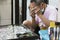 CHINATOWN BANGKOK-OCTOBER 9,2019:Seller using a small magnifying glass inspects an amulet for sale at his own shop. small