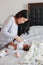 Chinese Asian busy mother changing diaper for newborn infant baby