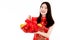 Chinese beautiful woman with long black hairs in red traditional dress is smiling and showing a red basket gift filled with