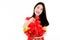 Chinese beautiful woman with long black hairs in red traditional dress is smiling and showing a red basket gift filled with