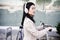 Chinese business woman renting electric scooter in city,wearing headphones.sustainable transport