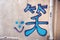 Chinese character for smile written in blue graffiti on a wall in Hong Kong