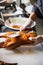 Chinese chef cooking peking roasted duck at the kitchen of restaurant