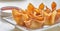 Chinese crab rangoon fried wontons on plate with red sauce