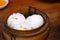 Chinese cuisine, hot and steamy dim sim or steamed Chinese dumplings were set in steamer basket. Steamed Buns