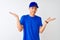 Chinese deliveryman wearing blue t-shirt and cap standing over isolated white background clueless and confused expression with