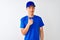 Chinese deliveryman wearing blue t-shirt and cap standing over isolated white background doing happy thumbs up gesture with hand