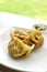 Chinese dumplings snack with soy sauce and ginger. On wooden table and green grass background