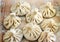 Chinese dumplings uncooked on wooden background. Street food booth selling Chinese specialty Steamed Dumplings.
