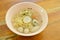 Chinese egg noodles topping fish dumpling and shrimp ball in clear soup on bowl