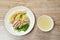 Chinese egg yellow noodles with barbecue pork and dumpling on plate with soup cup