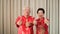 Chinese elderly senior couple in red costume thumb up gesture