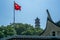 The Chinese flag fluttering in the wind with the West Pagoda on the Jiangxin island in Wenzhou in China in the background