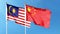 Chinese flag and Malaysian flag on cloudy sky. waving in the sky