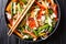 Chinese fresh vegetable salad with sesame and peanuts close-up on a plate. horizontal top view