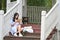 Chinese Girl reading book. Blonde beautiful young woman with book sit on the Pavilion steps.