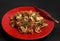 Chinese Glass noodles, tender chicken fillet, vegetables, champignons, ginger and soy sauces, green onions, sesame on a red plate