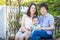 Chinese Grandmother, Daughter and Mixed Race Child Sit on Bench