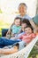 Chinese Grandparents In Hammock with Mixed Race Children