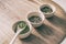 Chinese green tea loose leaves tasting selection wooden tray on table with three cups for drink tasting. Japanese matcha