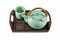 Chinese green teapot and teacups on the wooden trivet isolated