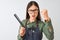 Chinese hairdresser woman wearing glasses holding comb over isolated white background annoyed and frustrated shouting with anger,