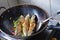 Chinese Home Cooking Fishes Fried in a Wok with Green and Red Chilies.