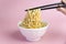 Chinese instant noodles. Asian food. White dish of noodles on an pink background, fast cheap food