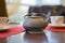 Chinese iron teapot and pair of ceramic cups on a wooden table in a cafe. Window in a background. Selective focus.