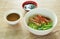 Chinese jade noodles topping roasted duck meat and cabbage dipping sweet soy sauce on bowl