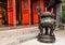 Chinese joss stick pot in front of red door of chinese temple in